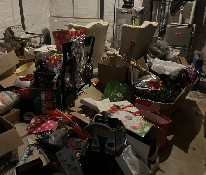 Cluttered basement storage with boxes, Christmas decorations, and furniture. Rubble Rumblers